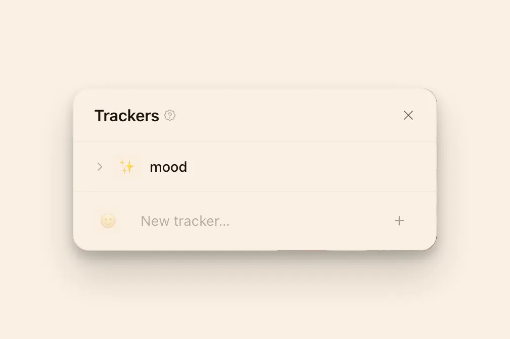 The Trackers panel with a sparkle emoji set on the Mood tracker and an empty emoji slot on the new-tracker row